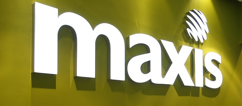 A customer walks past a logo of Malaysia’s mobile network operator Maxis at its headquarters in Kuala Lumpur